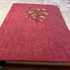Red notebook with an embroidered design on a textured surface